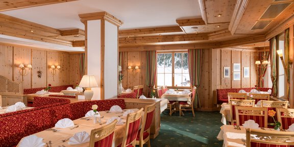 A cozy restaurant with wooden paneling and elegant tables. The atmosphere is warm and inviting, perfect for a lovely meal. - *** Hotel Venter Bergwelt - Restaurant Venter Einkehr - Vent