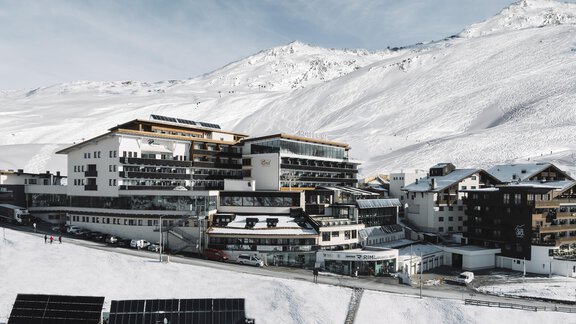 Ein modernes Hotel in einer schneebedeckten Berglandschaft. Die Umgebung ist ruhig und einladend, umgeben von schneebedeckten Gipfeln. - SKI | GOLF | WELLNESS Hotel Riml - Hochgurgl