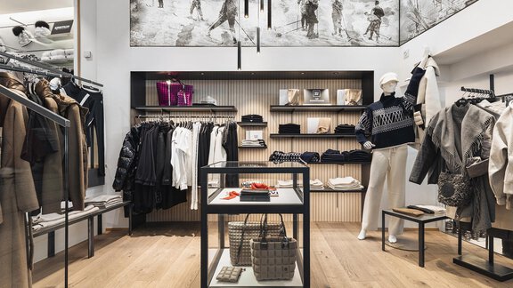 Ein eleganter Modegeschäft mit stilvoller Kleidung und Accessoires. Die hellen Holzfußböden und modernen Regale schaffen eine einladende Atmosphäre. - SKI | GOLF | WELLNESS Hotel Riml - Hochgurgl