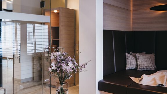 A modern room with a cozy seating area and a large glass wall. A floral arrangement adds a fresh accent. - The Crystal VAYA Unique - Obergurgl 