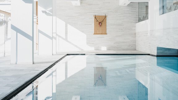 An elegant pool in a modern, bright room. The walls are adorned with white tiles, and there is plenty of natural light. - The Crystal VAYA Unique - Obergurgl 