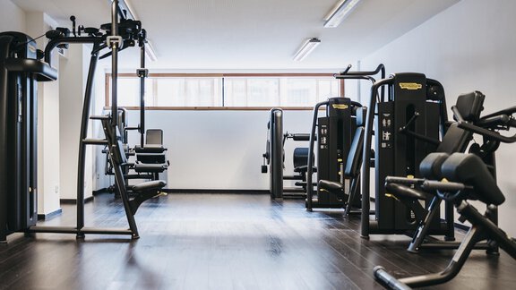 A well-equipped fitness room with various training equipment. The room is bright and clean with large windows. - The Crystal VAYA Unique - Obergurgl 