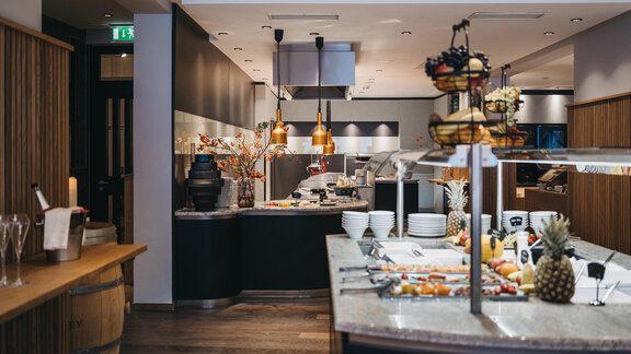 A modern restaurant with a rich buffet. The tables are set with fresh fruits and various dishes. - The Crystal VAYA Unique - Obergurgl 