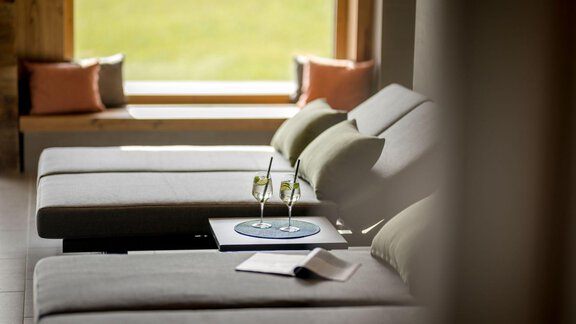 A relaxing room with loungers and a table. On the table are two glasses and a magazine. - Alpengasthof Grüner - Sölden