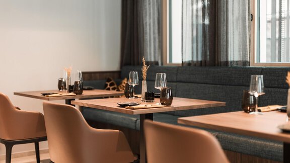 Ein stilvolles Restaurant mit modernen Tischen und Stühlen. Die Einrichtung ist hell und einladend, mit großen Fenstern und eleganten Accessoires. - AlpenParks The Secret Sölden - Sölden