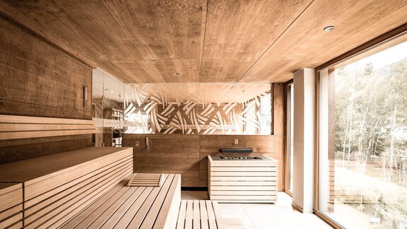 Eine moderne Sauna mit Holzwänden und -bänken. Große Fenster bieten einen Blick auf die Natur draußen. - AlpenParks The Secret Sölden - Sölden