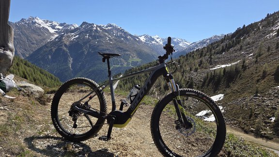 A mountain bike is at a viewpoint in the mountains. In the background, snow-covered peaks and a clear sky can be seen. - Apart Alpenjuwel - Sölden
