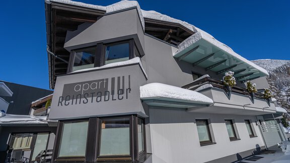 A modern building called "apart Reinstadler" in a snow-covered area. The clear blue sky complements the winter atmosphere. - Apart Reinstadler - Sölden