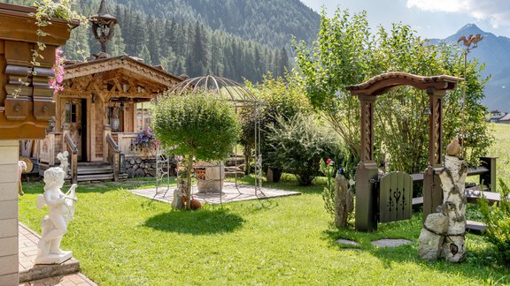 Ein malerischer Garten mit einer Holzlaube und schönem Grün. Im Hintergrund sind Berge zu sehen, die das Landschaftsbild abrunden. - Apart Wiesengrund - Sölden