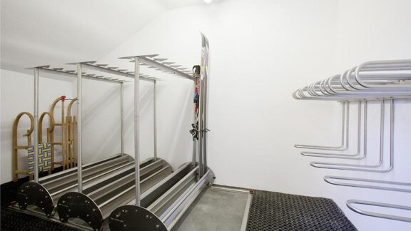 Ein moderner Skiraum mit Metallregalen für Ski und Snowboard. Die Wände sind weiß und der Boden ist mit rutschfestem Material ausgelegt. - Appartement Alpin - Sölden