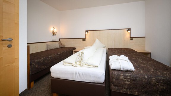 Ein einfaches und modernes Zimmer mit zwei Einzelbetten und neutralen Farben. Es gibt eine warme Atmosphäre durch die Wandbeleuchtung und die Holzdetails. - Appartement Alpin - Sölden