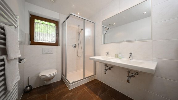 Ein modernes Badezimmer mit Duschkabine und großem Spiegel. Die Wände sind hell gefliest und es gibt eine angenehme Atmosphäre. - Appartement Alpin - Sölden