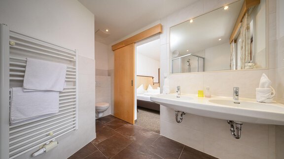 Ein modernes Badezimmer mit einer hellen Ausstattung und großen Spiegeln. Die Wände sind hell und es gibt eine Dusche sowie Handtuchhalter. - Appartement Alpin - Sölden