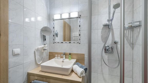 Ein modernes Badezimmer mit einer Dusche und einem Waschbecken aus Holz. Helle Fliesen sorgen für eine freundliche Atmosphäre. - Appartement Cristallo - Sölden
