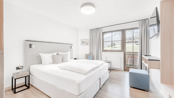 Ein modernes Schlafzimmer mit einem großen Doppelbett und viel natürlichem Licht. Die elegante Einrichtung sorgt für eine gemütliche Atmosphäre. - Appartement Montanara - Sölden