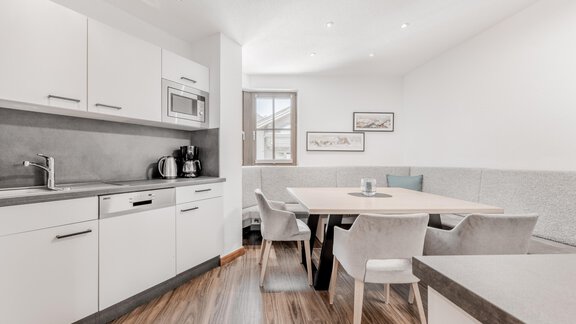 Eine moderne Küche mit einem Esstisch und eleganten Stühlen. Das Raumdesign ist hell und einladend. - Appartement Montanara - Sölden