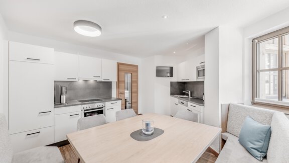 Eine moderne Küche mit einem großzügigen Essbereich. Helle Möbel und viel natürliches Licht schaffen eine einladende Atmosphäre. - Appartement Montanara - Sölden