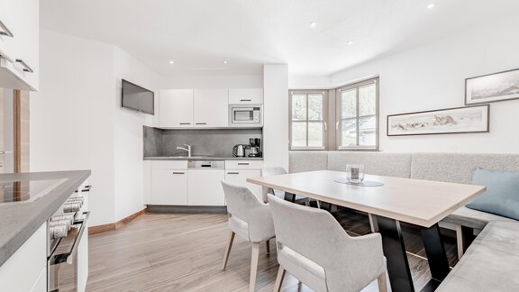 Eine moderne Küche mit einem Essbereich und eleganten Stühlen. Große Fenster sorgen für viel natürliches Licht. - Appartement Montanara - Sölden