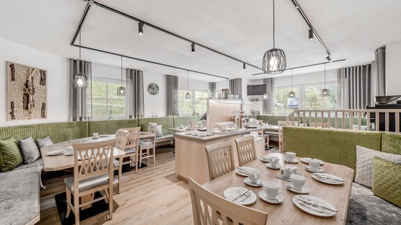 Ein stilvolles Restaurant mit modernen Holzmöbeln und gemütlichen Sitzbereichen. Die großen Fenster lassen viel Licht herein und schaffen eine einladende Atmosphäre. - Appartementhaus Kathrin - Sölden