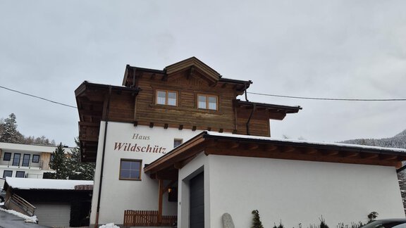 Ein traditionelles Haus mit einem Holzverkleidung und einem modernen Anbau. Schneebedeckte Straßen und eine ruhige Atmosphäre umgeben das Gebäude. - Appt. Wildschütz - Sölden