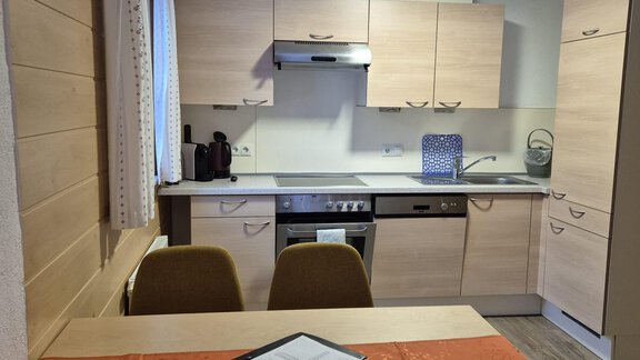Eine moderne Küche mit hellen Holzschränken und einem Esstisch. Das Raumdesign ist hell und einladend. - Appt. Wildschütz - Sölden