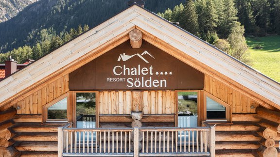 Ein charmantes Chalet mit Holzverkleidung in den Bergen. Das Schild "Chalet Resort Sölden" ist gut sichtbar. - Sölden