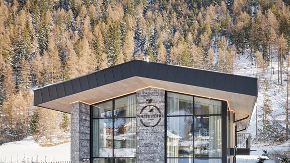 Ein modernes, architektonisch ansprechendes Haus in einer schneebedeckten Landschaft. Die Umgebung ist von schneebedeckten Bergen und Bäumen umgeben. - Chalet White Pearl by MYALPS - Sölden
