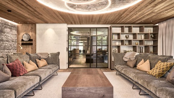 Ein modernes Wohnzimmer mit gemütlichen Sofas und bunten Kissen. Die Decke hat eine stilvolle Beleuchtung und der Raum wirkt einladend und hell. - Chalet White Pearl by MYALPS - Sölden