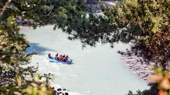 Eine Gruppe von Personen macht Rafting auf einem klaren Fluss. Umgeben von Bäumen und natürlicher Landschaft bietet die Szene ein Abenteuergefühl. - Chalet White Pearl by MYALPS - Sölden