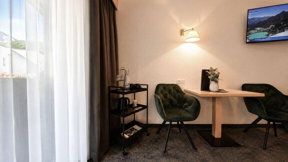A cozy workspace with a table and two chairs. A television and a front of windows provide pleasant light. - Garni Rustica - Sölden