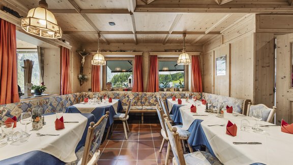Ein gemütliches Restaurant mit rustikalem Holzinterieur. Die Tische sind elegant gedeckt und bieten eine einladende Atmosphäre. - Gasthof Granstein - Sölden