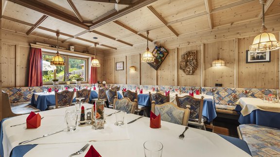 Ein einladendes Restaurant mit Holzwänden und gedeckten Tischen. Die Atmosphäre ist gemütlich, mit roten Servietten und warmem Licht. - Gasthof Granstein - Sölden