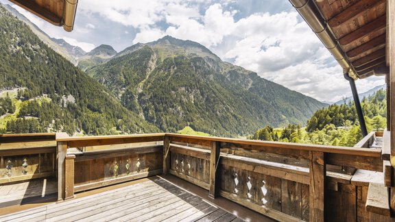 Ein schöner Balkon mit Holzgeländer und Blick auf die majestätischen Berge. Der Himmel ist teilweise bewölkt und die Landschaft ist grün und einladend. - Gasthof Granstein - Sölden