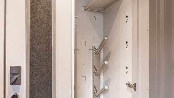 Ein geöffneter Aufbewahrungsschrank mit Regalen und speziellen Halterungen. Die Innenansicht zeigt eine moderne und funktionale Gestaltung. - Haus Manfred - Sölden