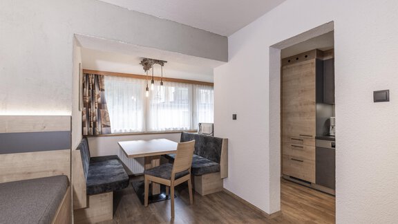 Ein modernes Wohnzimmer mit einer gemütlichen Sitzecke und einem Tisch. Die hellen Wände und das Holzfurnier schaffen eine einladende Atmosphäre. - Haus Manfred - Sölden