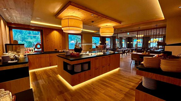 A modern restaurant with warm wooden interior and illuminated ceiling lamps. The area is inviting and well organized, with a pleasant atmosphere. - Hotel Garni Hainbacherhof - Sölden