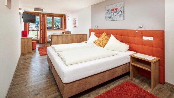 A modern hotel room with two separate beds and a cozy ambiance.  
Windows with a view of the countryside and tasteful decor create an inviting atmosphere. - Hotel Sunny Sölden - Sölden