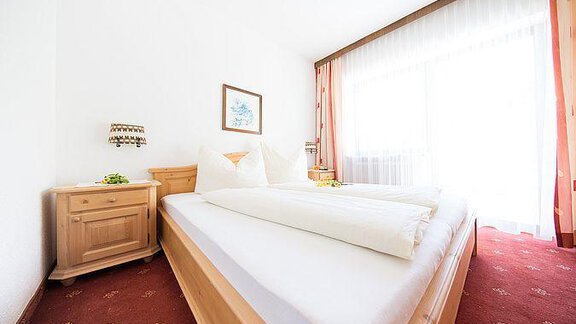 Ein helles und gemütliches Schlafzimmer mit zwei Einzelbetten. Große Fenster lassen viel natürlichem Licht herein. - Pension Charly - Sölden