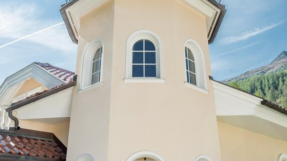 Ein modernes, helles Haus mit einem charakteristischen türmlichen Design. Der Himmel ist klar und die Umgebung ist grün und einladend. - Villa Castelbell - Sölden