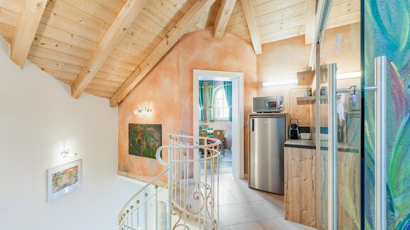 Eine moderne Küche mit Holzoberflächen und einem offenen Wohnbereich. Die Dachkonstruktion aus Holz verleiht dem Raum eine gemütliche Atmosphäre. - Villa Castelbell - Sölden