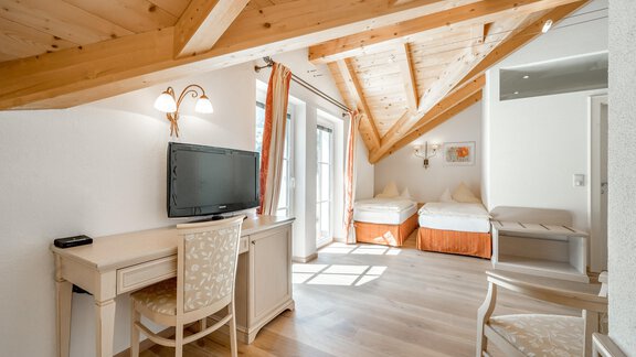 Ein helles Zimmer mit Holzbalkendecke und komfortablen Möbeln. Das Zimmer ist mit einem Schreibtisch, einem Fernseher und einem Blick nach draußen ausgestattet. - Villa Castelbell - Sölden