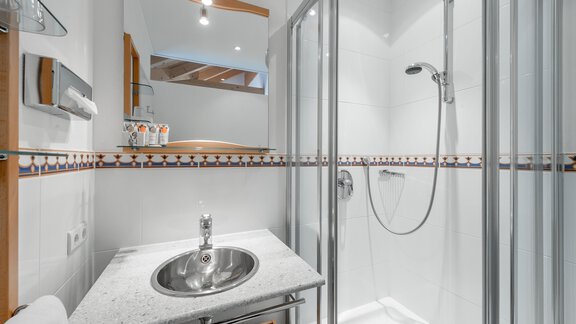 Ein modernes Badezimmer mit einer Dusche und einem Waschbecken. Die Wände sind hell, und es gibt eine elegante Fliese am Rand. - Villa Castelbell - Sölden