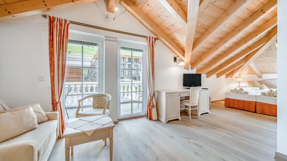 Ein gemütliches Zimmer mit Holzverkleidung und großen Fenstern. Es gibt ein Sofa, einen Tisch und einen Fernseher. - Villa Castelbell - Sölden