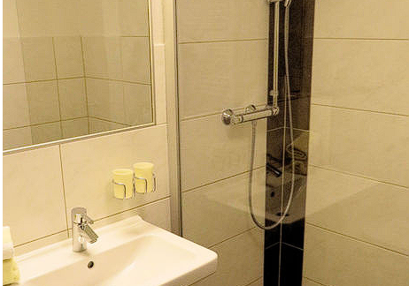 Ein modernes Badezimmer mit einer Glasdusche und einem Waschbecken. Die Wände sind hell gefliest und es gibt Pflegeprodukte auf dem Waschbecken. - Gästehaus Soldanella - Vent