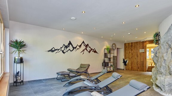 Ein ruhiger Wellnessbereich mit Liegen und beruhigender Bergwandgestaltung. Der Raum hat große Fenster und eine natürliche Atmosphäre. - Hotel Vent - Vent