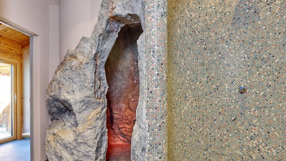 Ein moderner Wellnessbereich mit einem rockigen Eingang zu einem Dampfbad. Die Wand ist mit bunten Mosaikfliesen gestaltet. - Hotel Vent - Vent