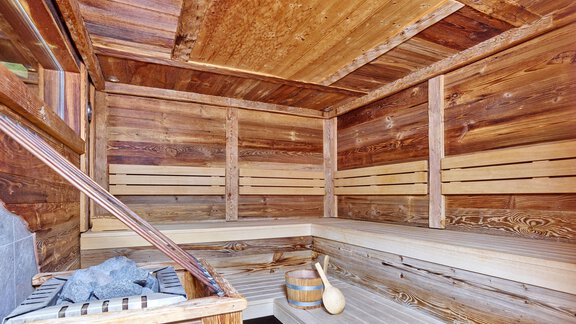 Eine gemütliche Sauna aus Holz mit Bänken und einem Ofen. Der Raum strahlt Entspannung und Wärme aus. - Hotel Vent - Vent