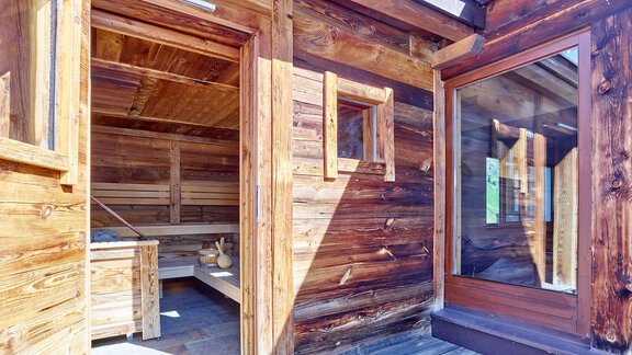 Eine gemütliche Holzhütte mit großen Fenstern. Der Innenraum zeigt eine Sauna und entspannende Atmosphäre. - Hotel Vent - Vent