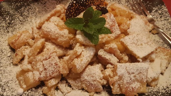 A plate with sweet apple strudel, dusted with powdered sugar. A fresh mint leaf garnishes the top. - Mein Weisskugel - Vent