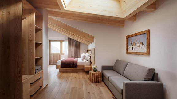 Ein modernes Zimmer mit Holzdetails und einem großen Fenster im Dach. Es gibt ein Bett, eine Couch und einen kleinen Tisch. - Chalet s’Tyrolia - Zwieselstein